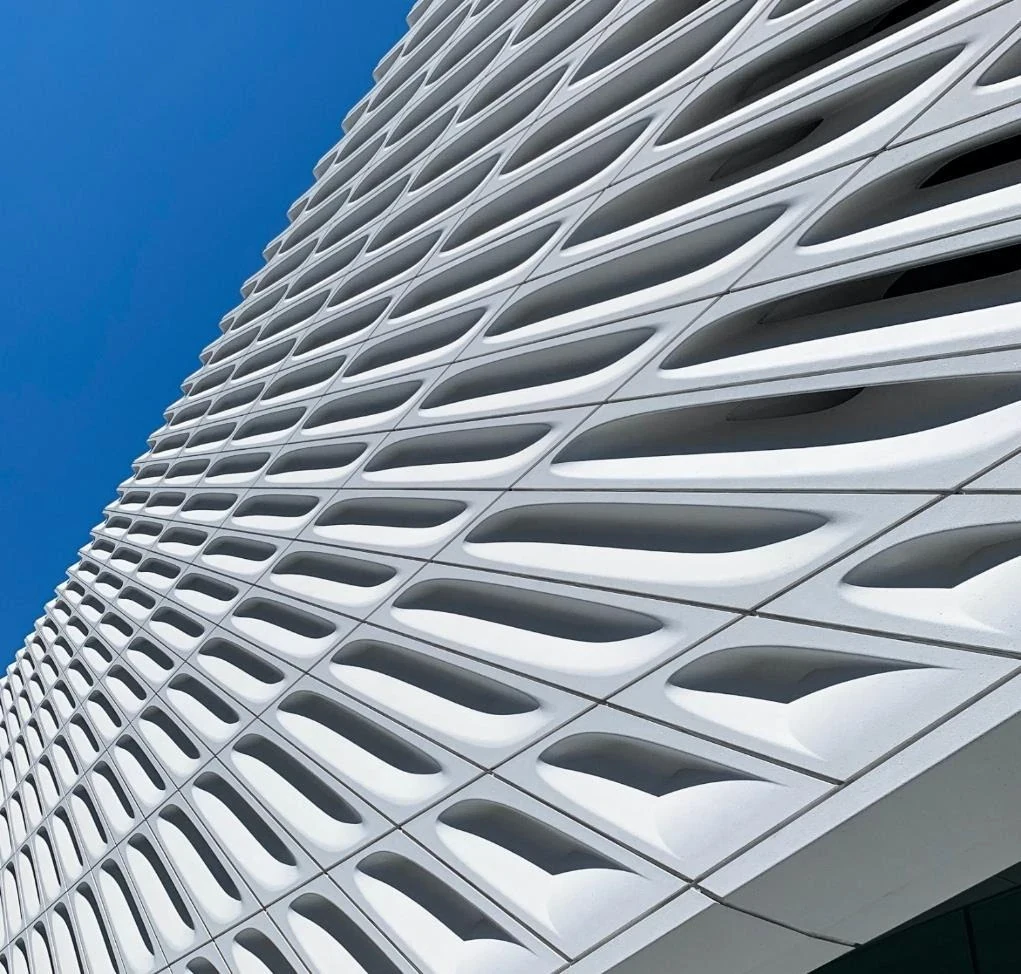Sculptural white building facade against a clear blue sky